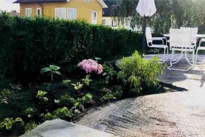哥德堡Eget hus i Örgryte. Göteborgs bästa läge!的花园设有桌椅和植物