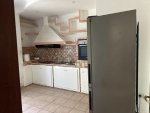 奥尔比亚Olbia via modena的厨房配有白色橱柜和黑色冰箱。