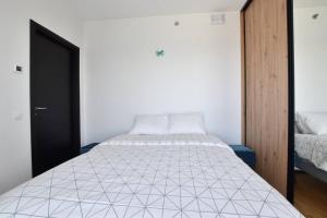 塔林Amazing High-Rise 1BR with 11th Floor Views的卧室配有带白色棉被的床
