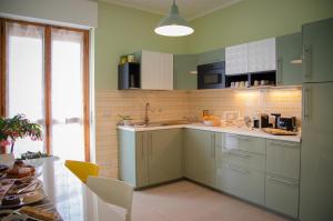 MurisengoMonferrato Bed&Bike的厨房配有绿色橱柜和水槽