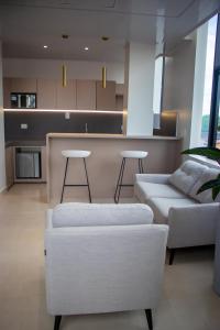 新洛哈Hotel Amazonas Suite, Suite Presidencial的一间带白色沙发的客厅和一间厨房