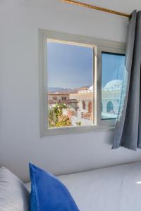 达哈布Al Deira Dahab Hotel的一间卧室设有窗户,享有城市美景