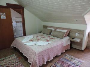 新彼得罗波利斯巴罗尼萨旅馆的一间卧室配有一张带粉色毯子的大床