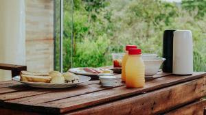 戈亚斯州上帕莱索Dolaço na Chapada- Hospedagem的餐桌,带食物盘和一瓶橙汁