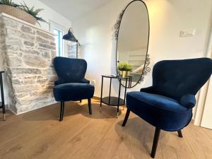 斯普利特Mariani studio apartments old town的一间设有两张蓝色椅子和镜子的房间