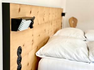 Valchava菲勒哈中央高级酒店的一张带白色枕头的木制床头板的床