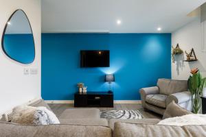 谢菲尔德Brand New Studio Apartment in Sheffield的带沙发和蓝色墙壁的客厅