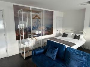 KentDartford Town 3 Bed by Harlington的一间卧室配有一张床和一张蓝色的沙发