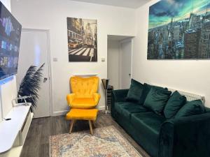 KentDartford Town 3 Bed by Harlington的客厅配有绿色沙发和黄色椅子