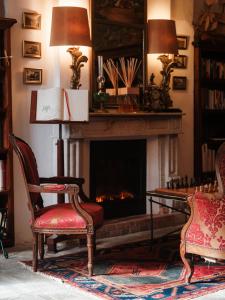 厄尔巴隆加Demeure Castel Brando Hôtel & Spa的客厅设有壁炉和2把椅子
