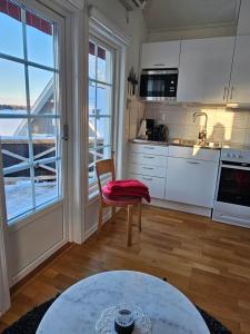 ÅkeröToppstugan的厨房配有白色橱柜、桌子和窗户。