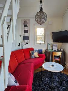 ÅkeröToppstugan的客厅配有红色的沙发和桌子