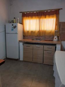 吉亚迪诺镇Casa V.Giardino pileta y cochera的一间带水槽和冰箱的小厨房