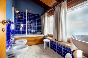 圣马力诺切萨雷酒店的蓝色瓷砖浴室设有2个卫生间和水槽