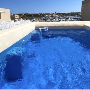 兰佩杜萨美杜莎酒店的一座建筑物顶部的蓝色海水游泳池