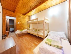 ľubochňaHorská chata Smrekovica的一间卧室设有两张双层床和木制天花板。