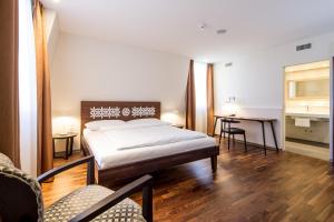 巴塞尔巴塞尔施维瑟酒店的卧室配有一张床和一张桌子及椅子