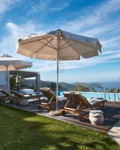 KechriaLuxury Villa in Kechria 2的一个带椅子和遮阳伞的庭院和一个游泳池