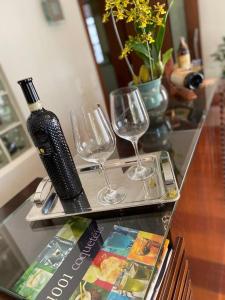 圣罗克Casa em São Roque Roteiro do Vinho的一张桌子,上面放着两杯酒和一瓶葡萄酒