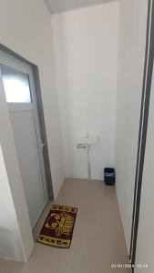 SiborongborongARIRANG27 HOMESTAY的一个小浴室,带门和地毯