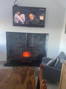BroadfordCosy Cottage Broadford的客厅设有壁炉和平面电视