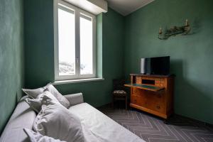 博尔戈塞西亚Villa Agnona Camere的一间卧室配有一张床,梳妆台上配有电视
