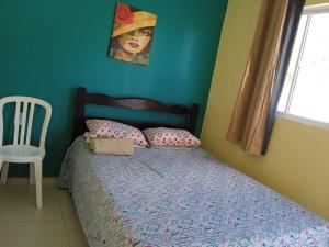帕拉库鲁Pousada Vista Verde的卧室配有一张床铺,墙上挂着一幅女画