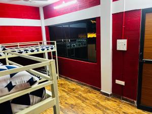 蓬蒂切里Hostel kuruku santhu colive的客房设有两张双层床和红色的墙壁。