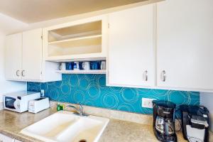 萨默兰Lillie Adventure的厨房配有水槽和白色橱柜