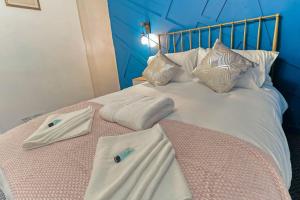 克劳奇河畔伯纳姆Beautiful 3-Bed Cottage in Burnham-on-Crouch的一张带两条毛巾和枕头的床