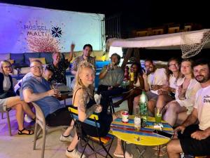 圣朱利安斯Hostel Malti Budget的一群坐在桌子旁喝着饮料的人