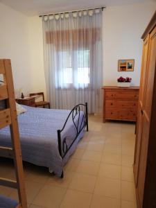 皮斯蒂奇Casa Vacanza Angela的一间卧室配有一张床、一个梳妆台和一扇窗户。
