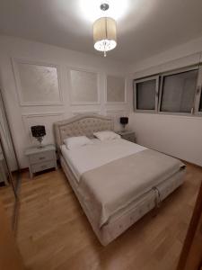 布德瓦Jana apartment Budva的一间卧室配有一张大床和一个吊灯。