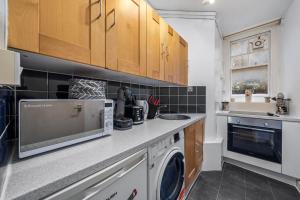 伦敦Chic Urban Retreat 1 Bedroom Gem in Covent Garden 3AB的厨房配有洗衣机和烘干机
