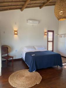 托鲁斯Amigos do Vento Pousada e Kite Point的一间卧室配有一张床、一把椅子和地毯