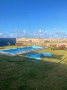 托鲁斯Amigos do Vento Pousada e Kite Point的田野中间的大型游泳池