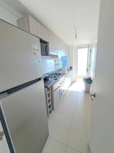 伊基克LABBE Departamento Hermosa Vista al Mar的白色的厨房配有冰箱和炉灶。
