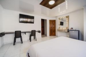 巴兰基亚Villa Santos Apartaestudios的一间卧室配有一张床、一张桌子和两把椅子