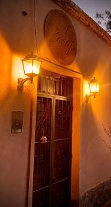 蒂诺加斯塔El Cortijo Tinogasta的墙上有门和灯的建筑
