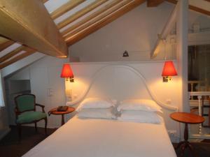 巴黎德格尔巴黎圣母院酒店的一间卧室配有一张白色床、两盏灯和两把椅子