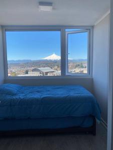 比亚里卡Departamento nuevo en Villarrica的一间卧室设有蓝色的床和2个窗户。