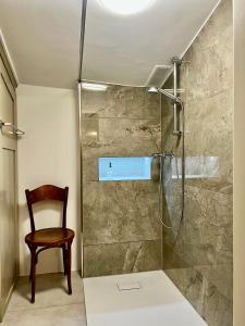 圣加仑Villa Bergruh的带淋浴和木椅的浴室