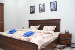 塔什干Chinara Guest House Airport的一间卧室配有一张带蓝色枕头的床。