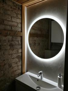 于韦斯屈莱Harmooni Suites的一间带水槽和圆镜子的浴室