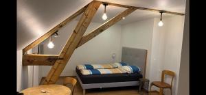 Couvet科维市中心舒适一室公寓的一间设有床铺的客房和一个带灯光的楼梯