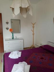 兰佩杜萨Splendido appartamento a Lampedusa, con terrazzo !的一间卧室配有床和带毛巾的梳妆台。