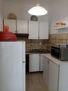 兰佩杜萨Splendido appartamento a Lampedusa, con terrazzo !的厨房配有白色橱柜、水槽和微波炉