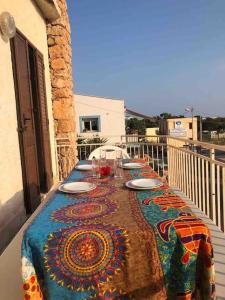 兰佩杜萨Splendido appartamento a Lampedusa, con terrazzo !的阳台上的桌子上摆放着盘子和酒杯