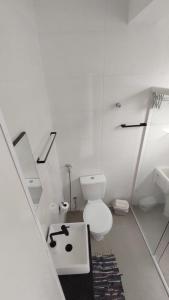 圣维森特岛Studio com bela vista para o mar的白色的浴室设有卫生间和水槽。