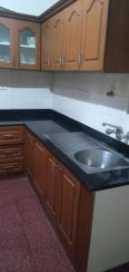 班加罗尔Brookefield Service Apartment的厨房配有黑色台面和水槽